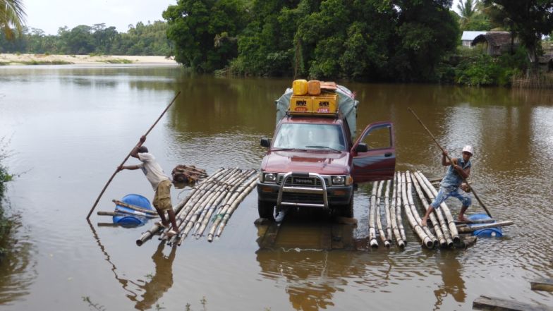 Landrover crossing a river on a raft in north-eastern Madagascar